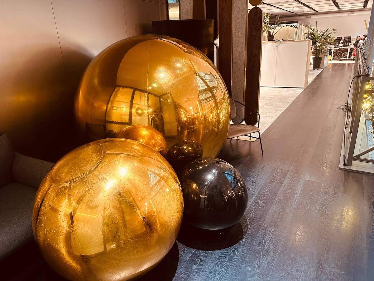 Ballons miroirs dorés et noirs posés au sol