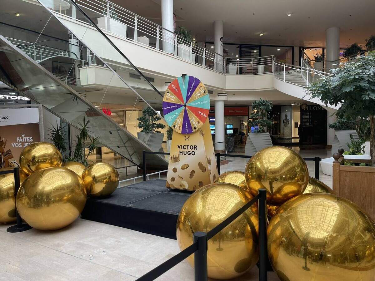 Ballons miroirs dorés disposés autour d’une animation commerciale