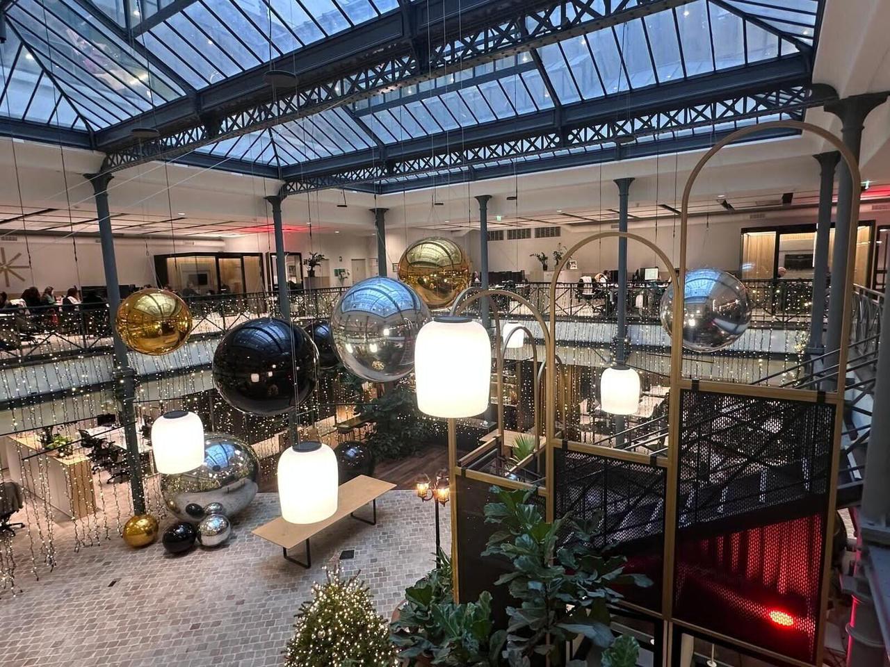 Ballons miroirs dorés, argentés et noirs dans un atrium