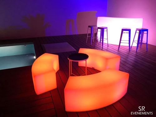 Bancs lumineux arrondis en orange autour d’une table basse