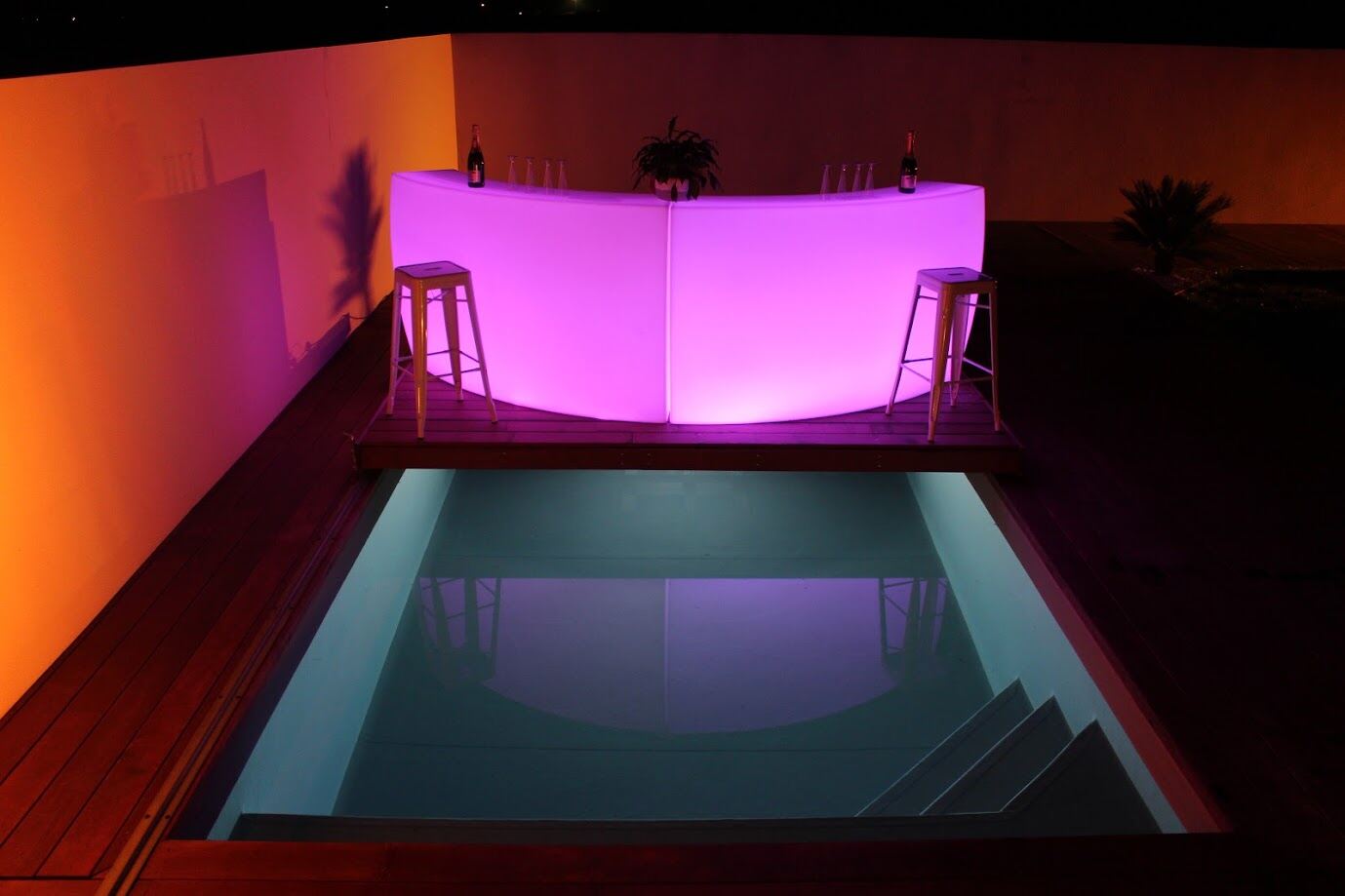 Bar arrondi lumineux rose pendant une réception en extérieur