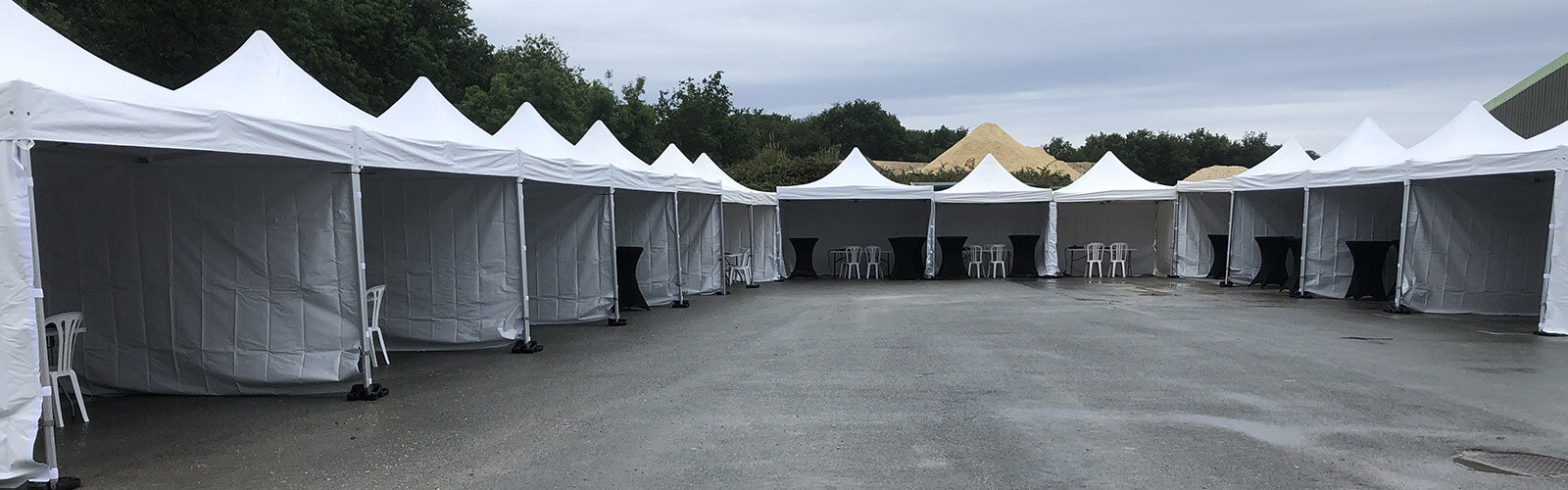Installation de nombreux barnums blancs autour d’un espace extérieur
