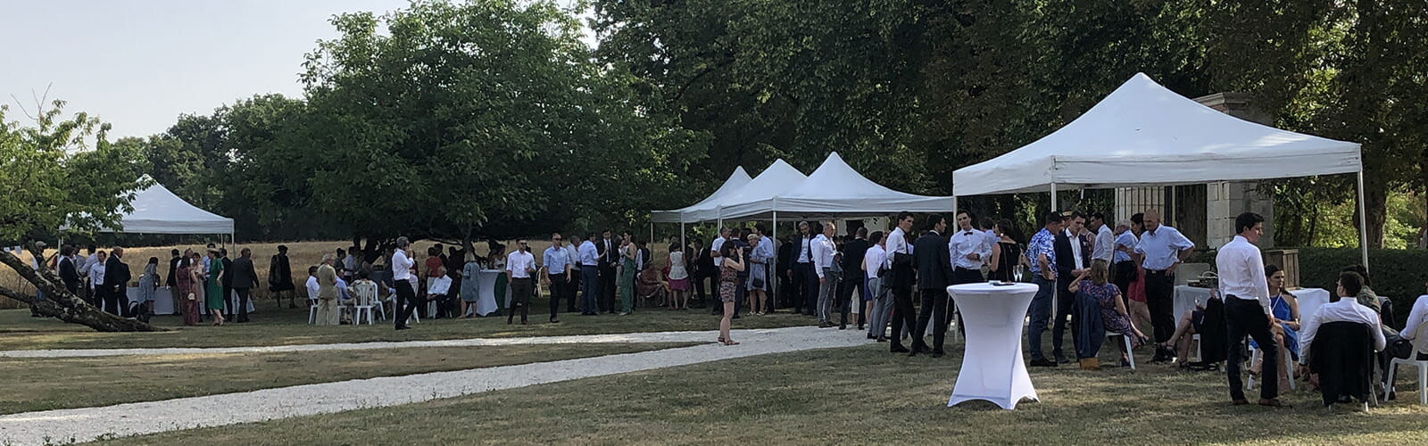 Barnums blancs installés dans un jardin lors d’un mariage