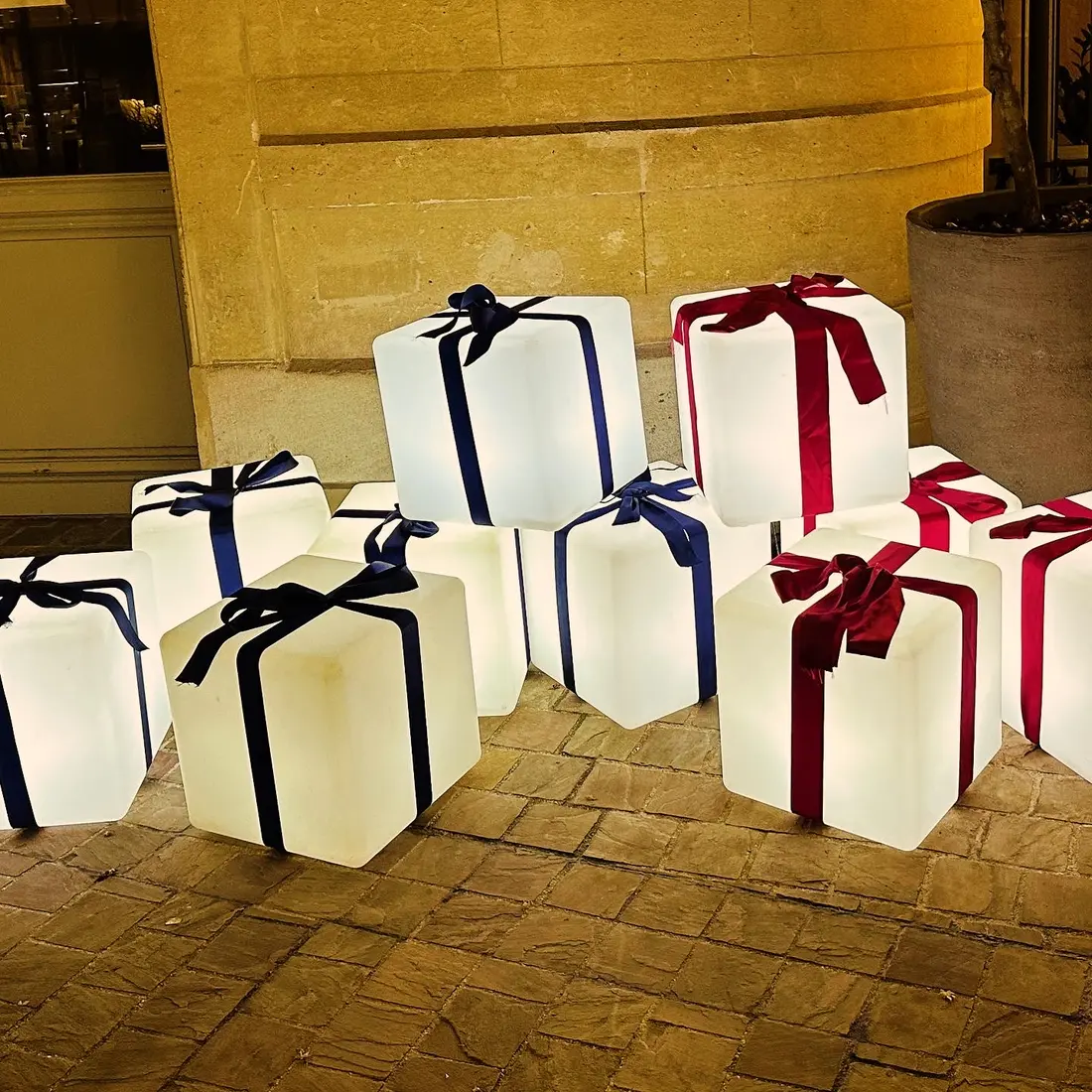 Ensemble de cadeaux lumineux blancs de différentes tailles avec rubans rouges et bleus