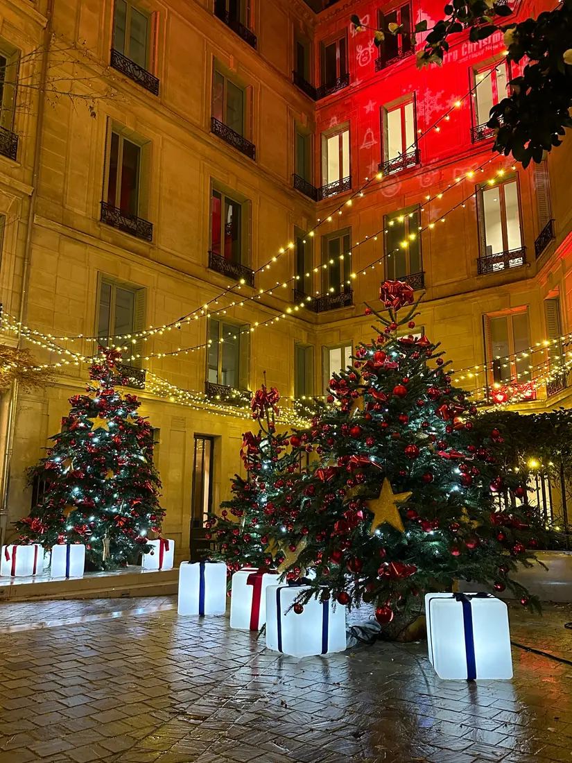 Vue verticale de sapins et cadeaux lumineux dans une cour de Noël