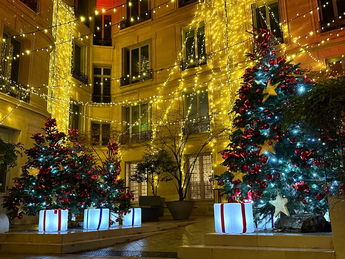 Cadeaux lumineux rouges et bleus au cœur d’une scénographie de Noël