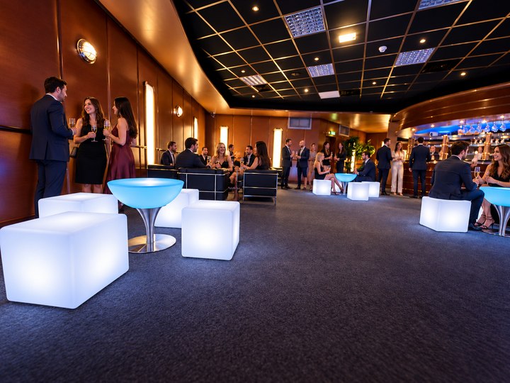 Cubes lumineux blancs associés à des tables bleu glacier dans une salle de réception
