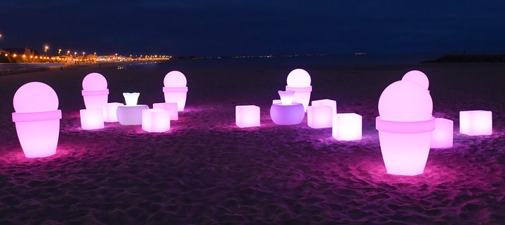 Cubes et mobilier lumineux multicolores sur une plage de nuit