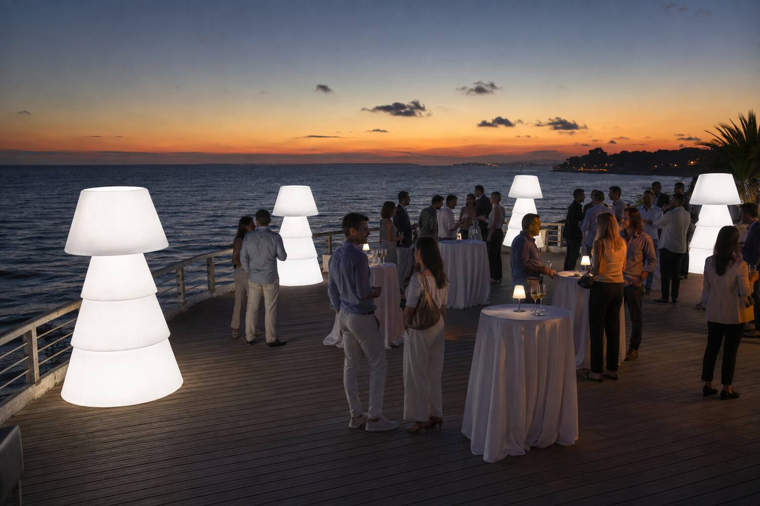 Lampadaires lumineux géants pour un cocktail face à l’océan au coucher du soleil