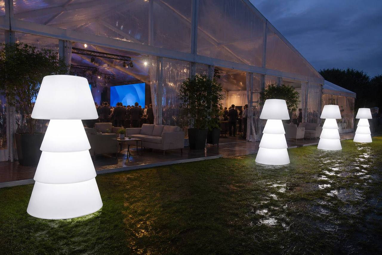 Lampadaires LED blancs installés devant une tente de réception transparente