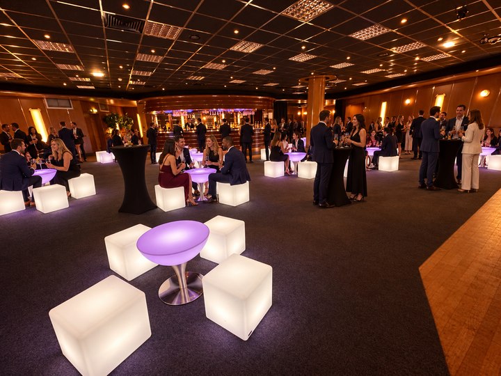 Table Lounge lavande avec pied en inox parmi des assises perle et invités en soirée