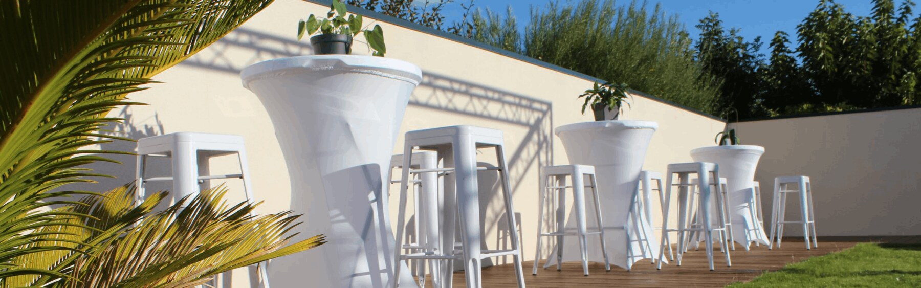 Mange-debout blancs avec tabourets Tolix sur une terrasse