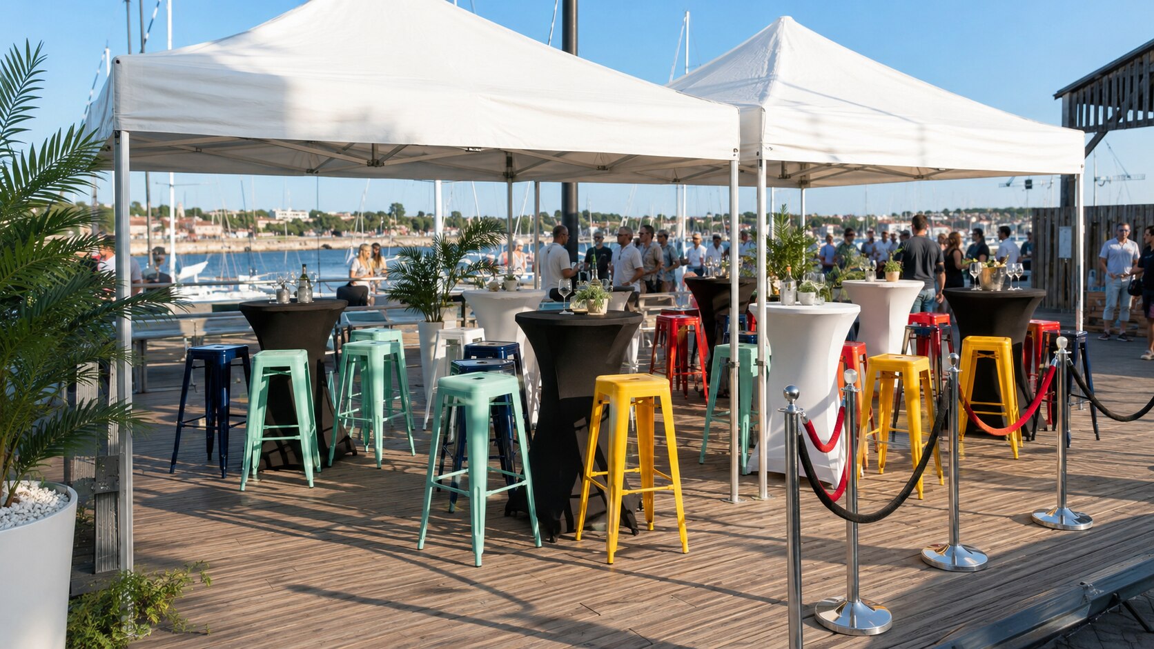 Barnums, mange-debout et tabourets colorés installés sur un port