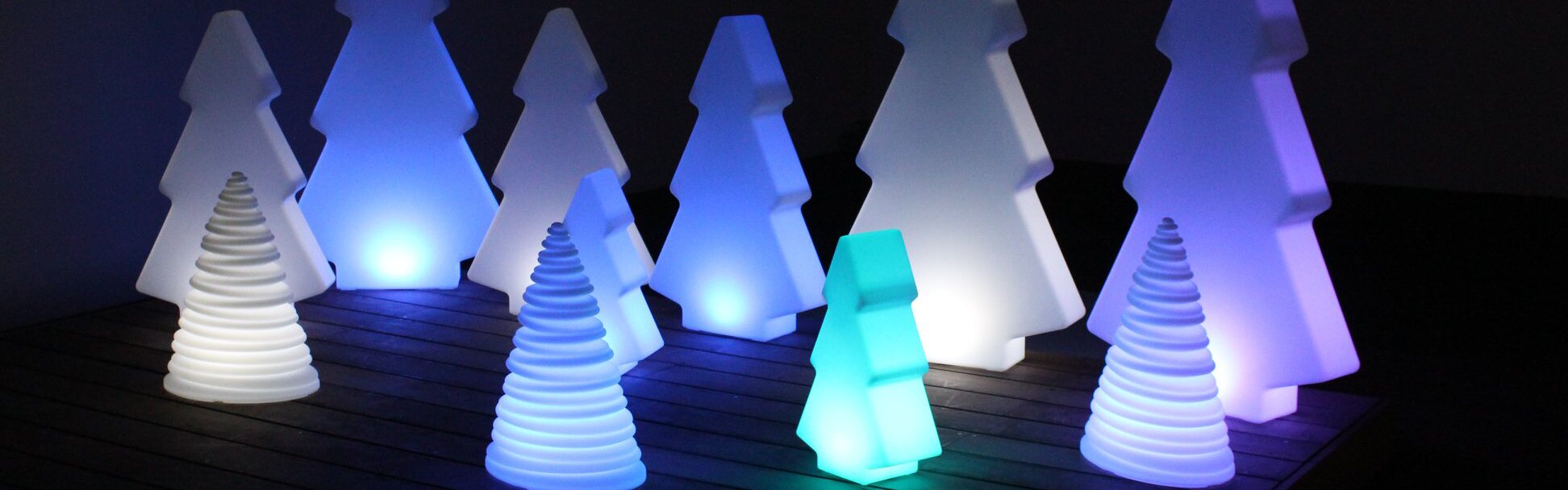 Sapins lumineux de silhouettes et hauteurs différentes