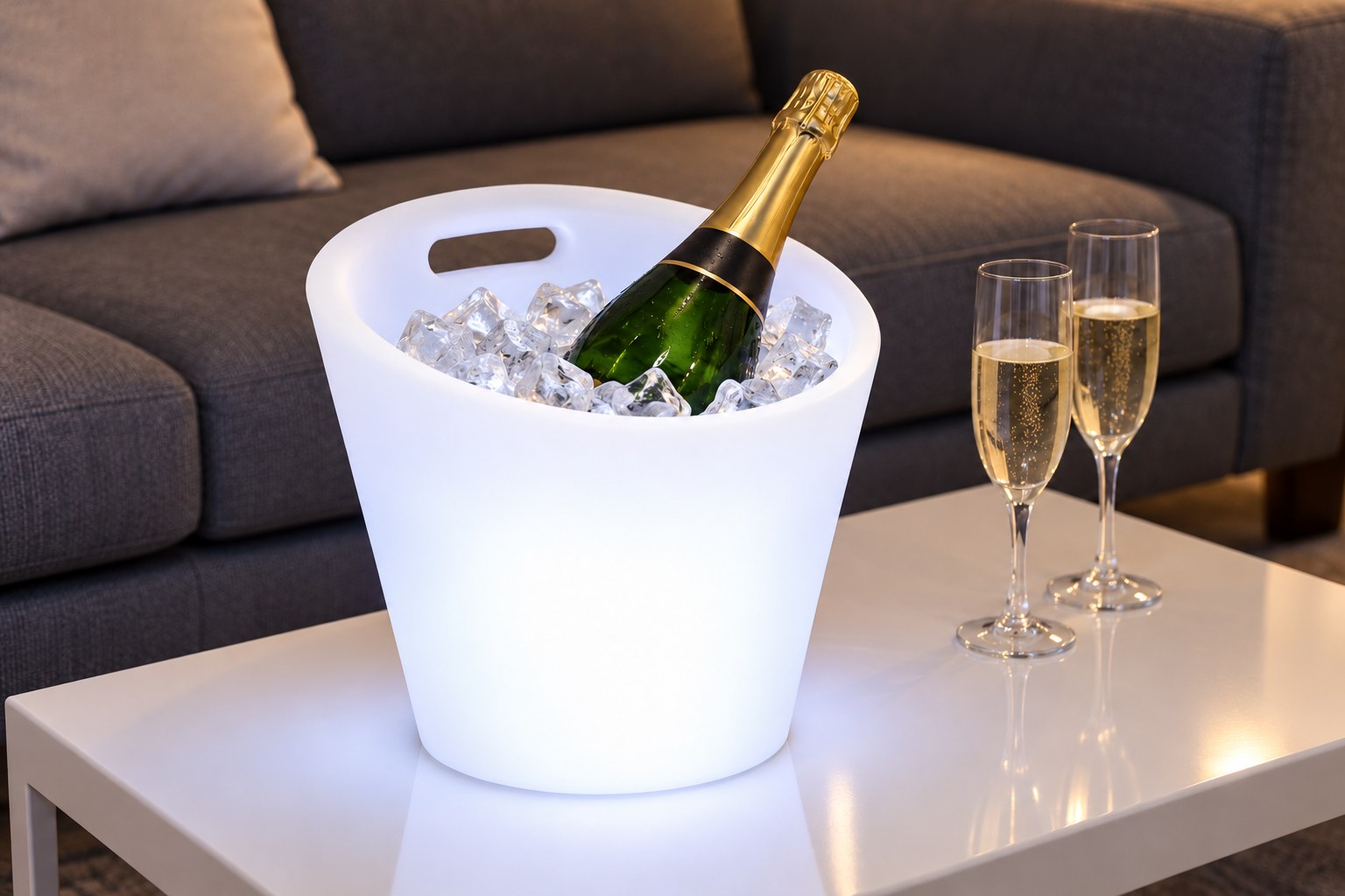 Seau lumineux à poignées blanc sur une table basse blanche devant un canapé
