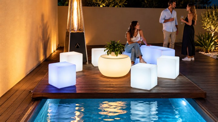 Table ronde ambrée et cubes blancs au bord de la piscine lors d’une réception