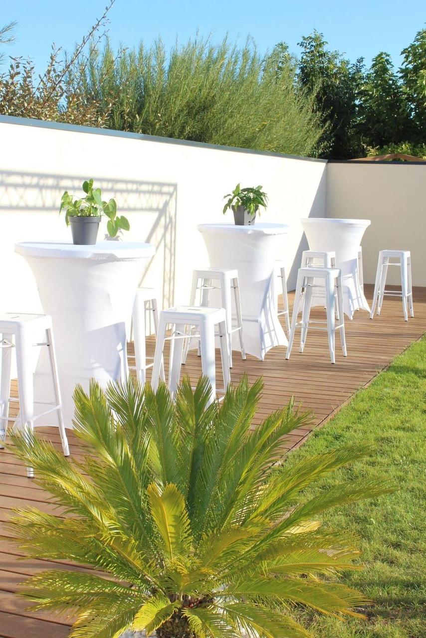 Vue verticale de tabourets hauts acier blancs et mange-debout dans un jardin