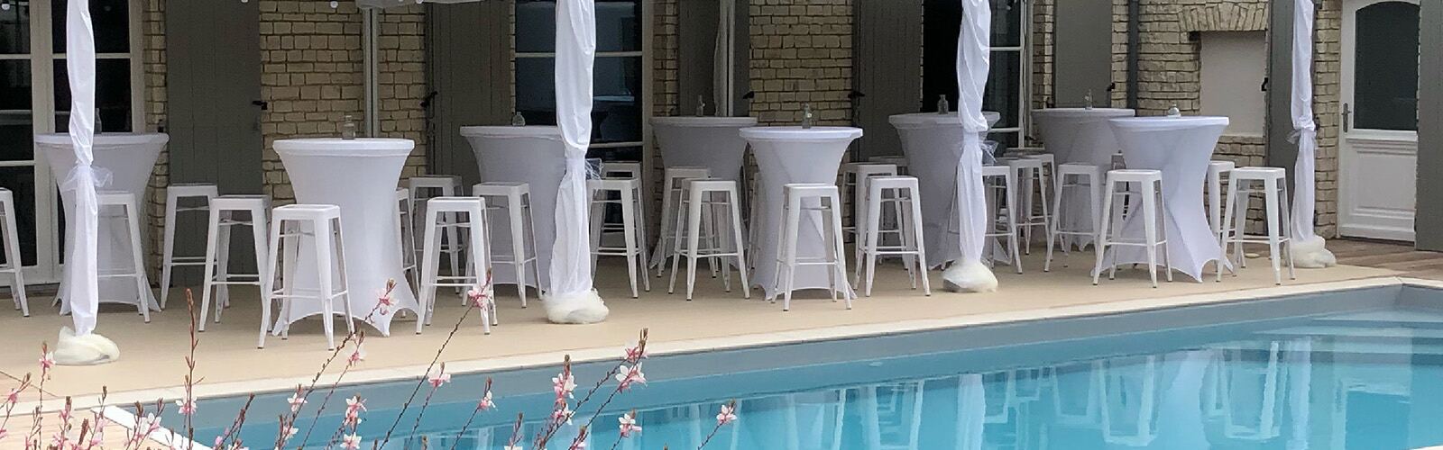 Tabourets hauts acier blancs près d’une piscine