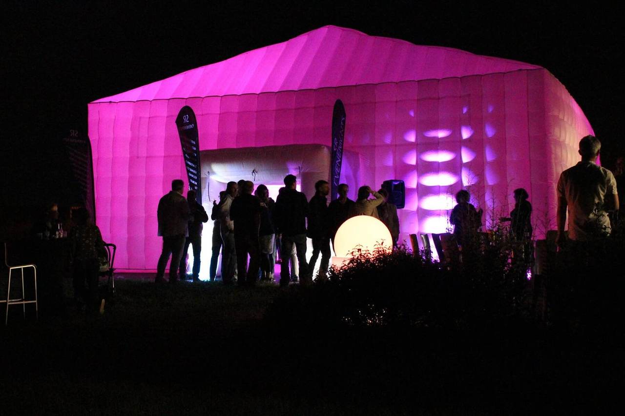 Tente gonflable de réception éclairée en rose avec ses invités